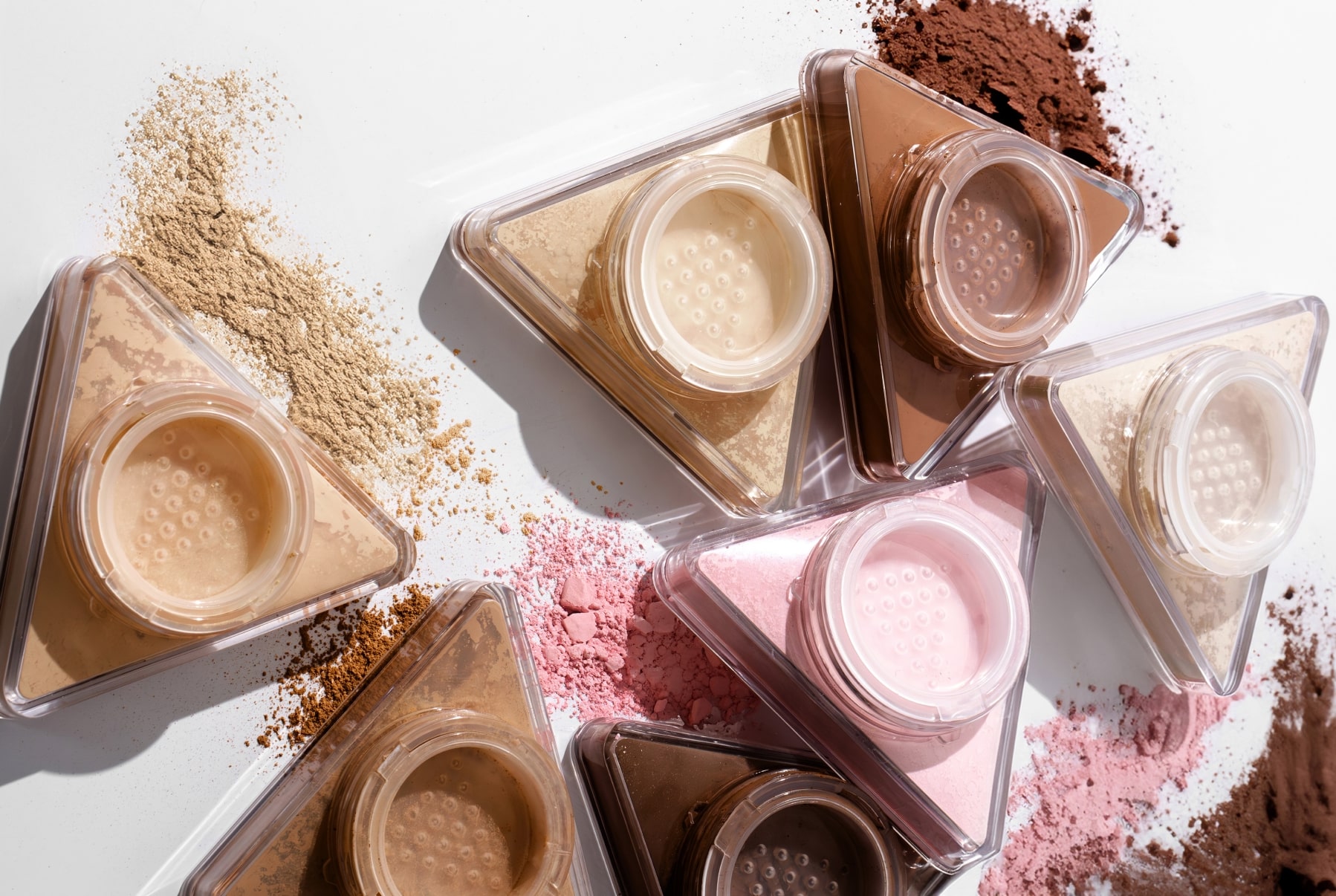 LYS Beauty setting powders and swatches arranged on a white table
