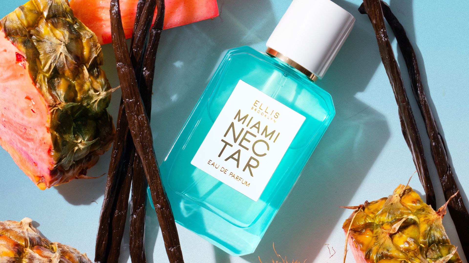 A bottle of Ellis Brooklyn Miami Nectar eau de parfum among tropical fruit and vanilla beans